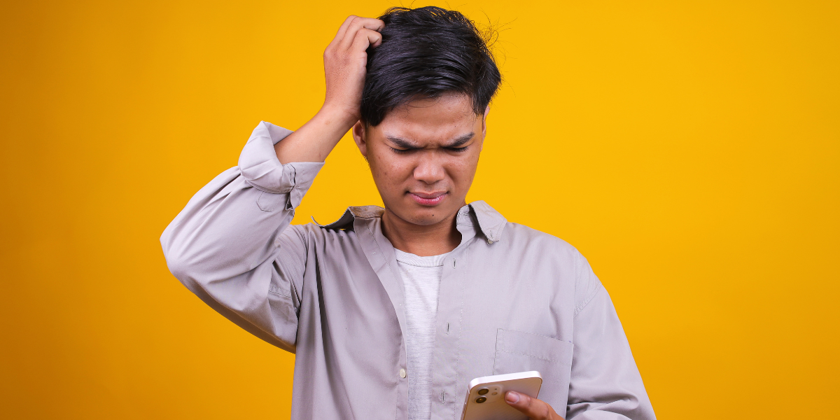 man die verward naar zijn smartphone kijkt